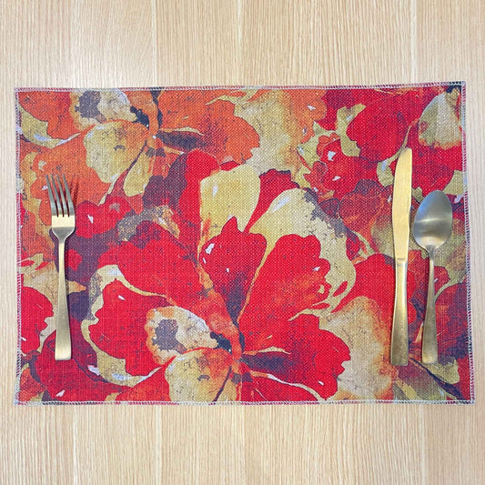 Rectangular Marigold Detail placemat with layered red, orange and gold flowers, on a wooden tabletop with gold cutlery.