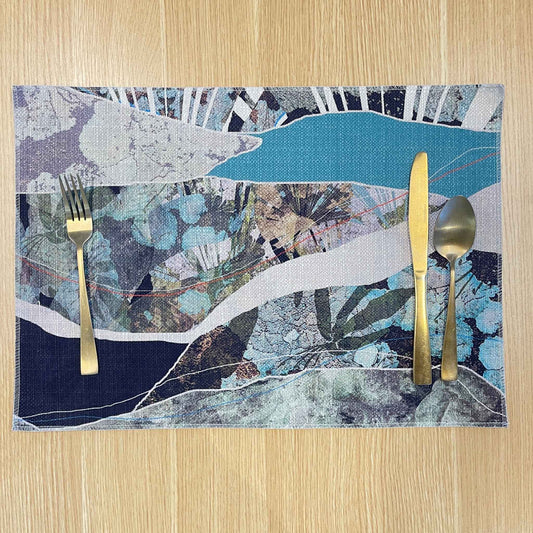 Rectangular Modern Coastal placemat with flowing aqua, grey and navy abstract bands, on a wooden tabletop with gold cutlery.
