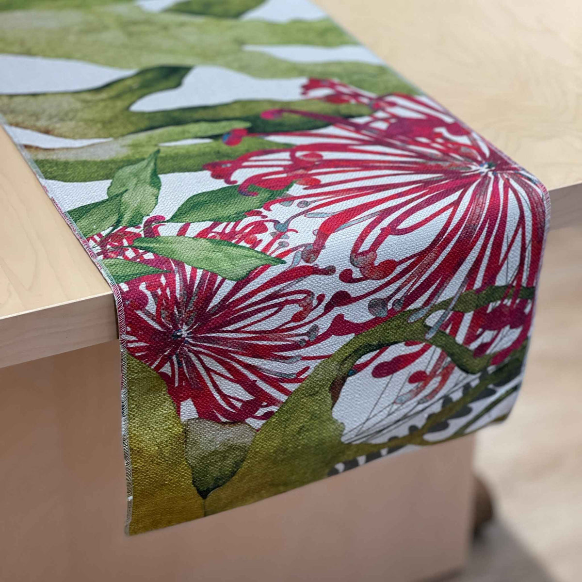 Binna Burra table runner with pink-red native flowers among green and yellow foliage