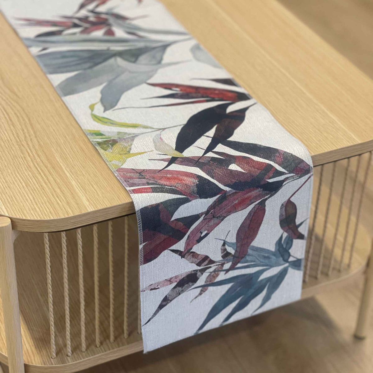 Cordyline table runner with layered charcoal, burgundy and olive tropical leaves