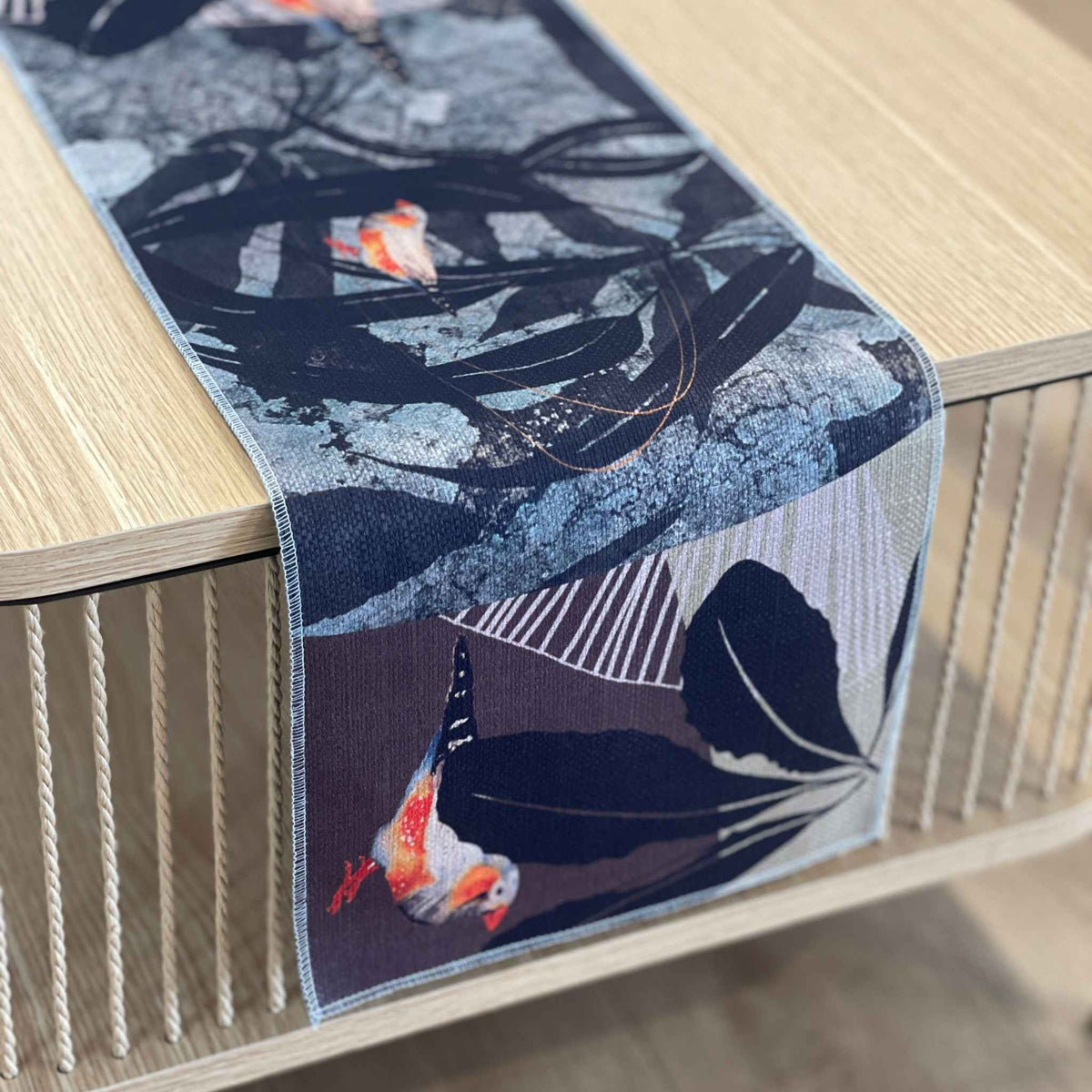 Finch Canopy table runner with orange and grey finches among dark leaves and fine botanical lines
