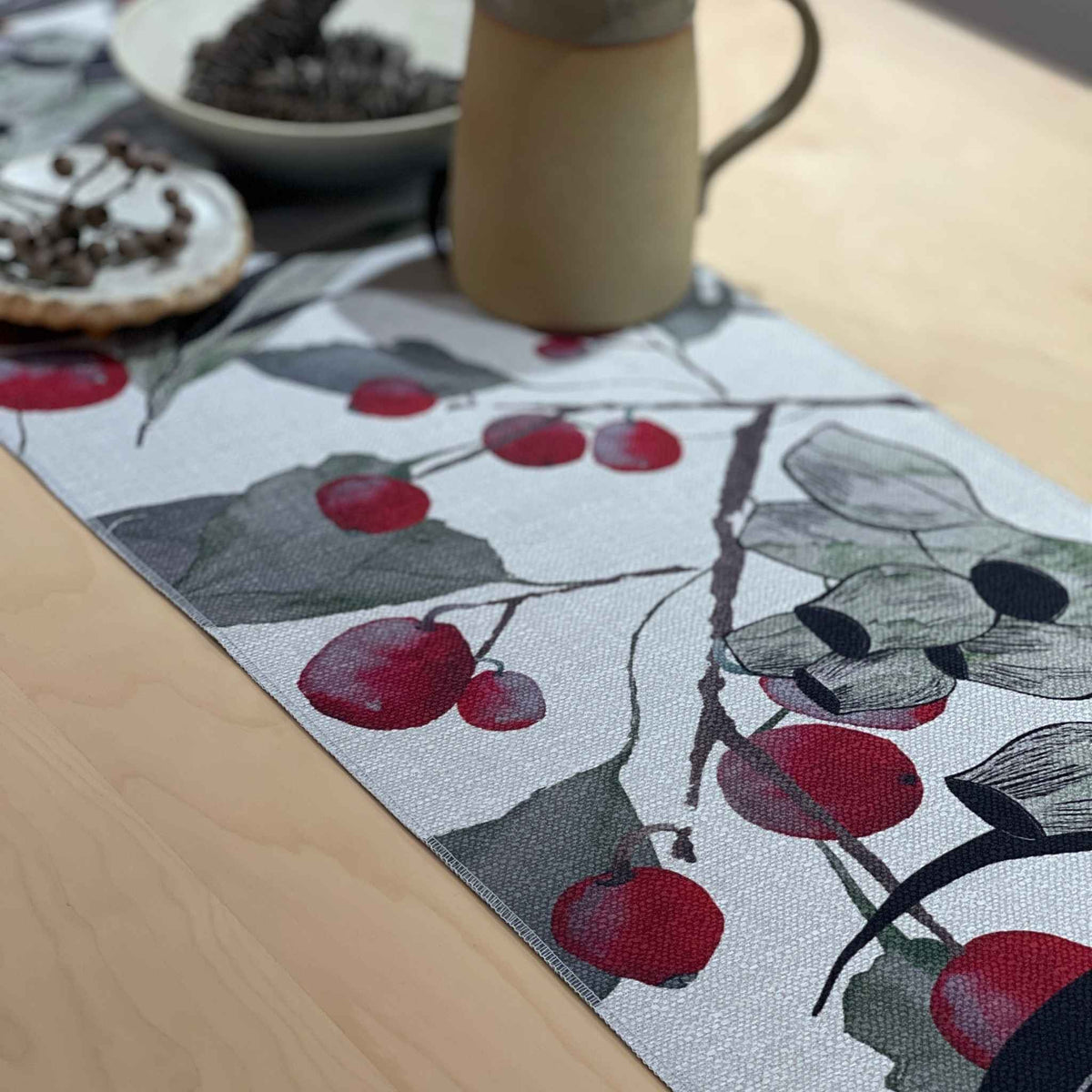 Bush Celebration table runner with red gum blossoms and berries among grey-green foliage and dark curved lines